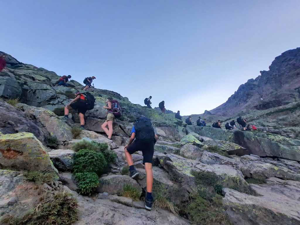 Des collégiens avancent sur les crêtes du Monte Cinto lors de leur première grande randonnée en montagne.