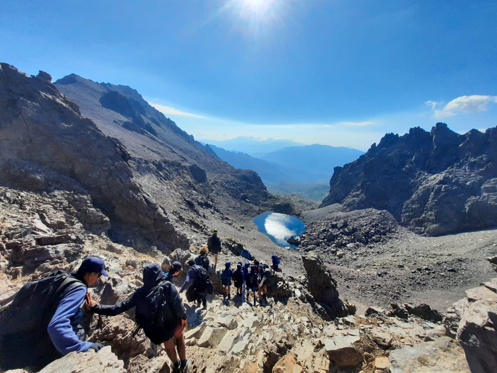 Des collégiens de Saint-Denis et de Cannes La Bocca redescendent du Monte Cinto en longeant le lac du Cinto, un lac glaciaire de haute montagne en Corse.