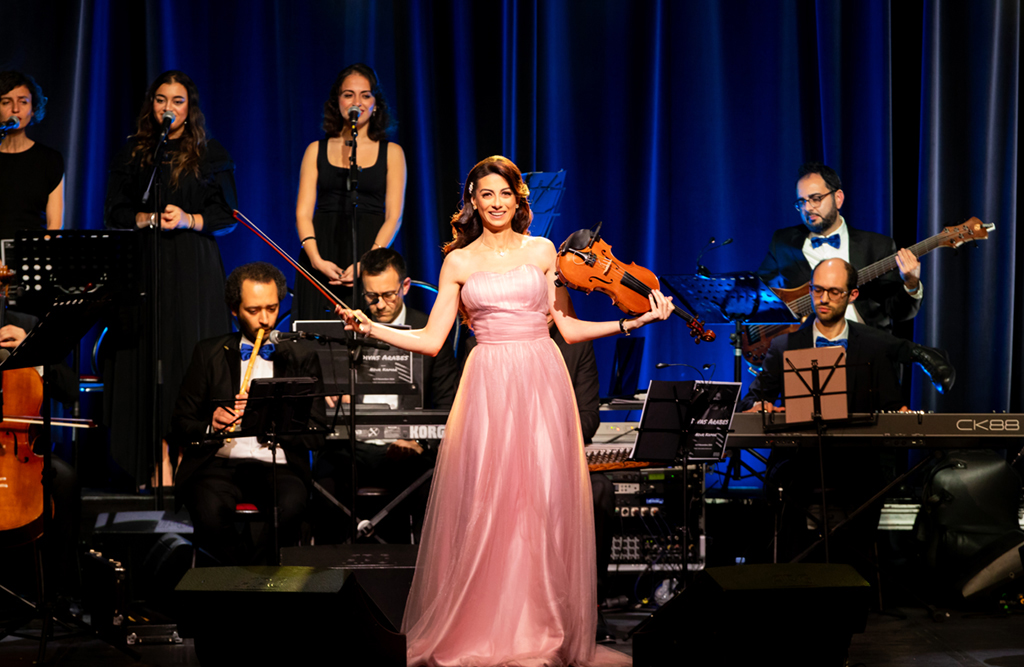 Amal Guermazi dirige l’orchestre Mazzika sur scène.