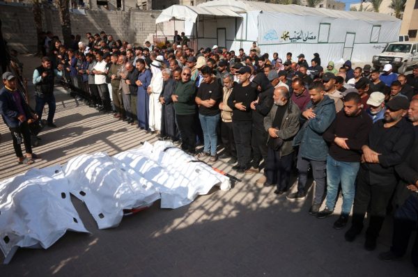 Palestiniens priant sur des corps après une frappe israélienne à Khan Younès.