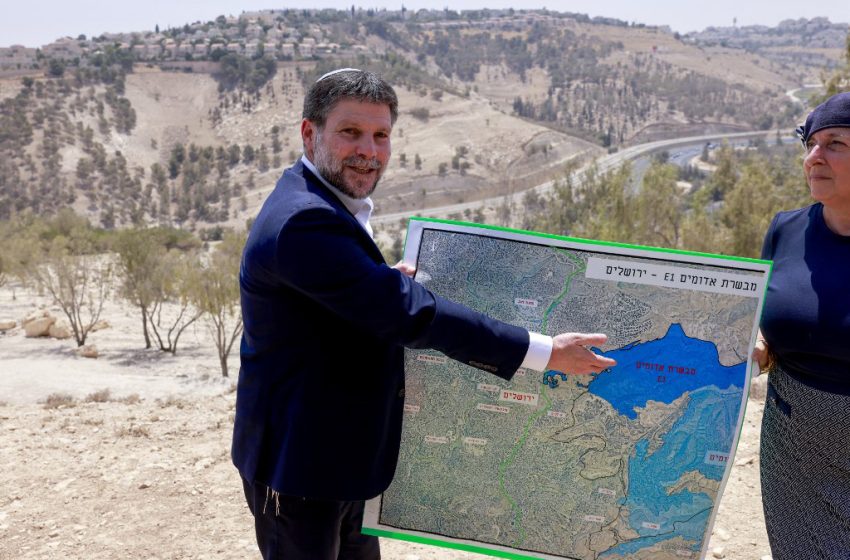 Bezalel Smotrich montre une carte du secteur E1 lors d’une conférence de presse en plein air près de Maale Adumim, en Cisjordanie occupée, à proximité de Jérusalem. Le site est présenté dans le cadre de projets d’extension de colonies et d’infrastructures dans la zone.
