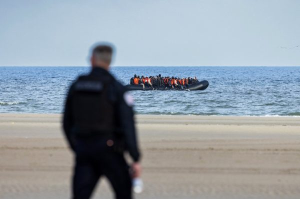 Un policier français tente d’empêcher des migrants d’embarquer sur une embarcation de passeurs au large de la plage de Gravelines, dans le nord de la France, le 26 mars 2025.
