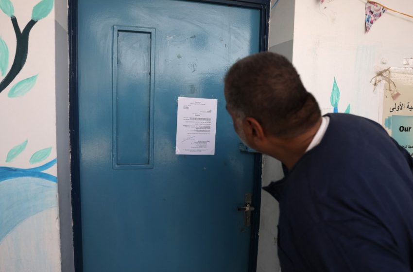 Des Palestiniens devant une école de l'UNRWA fermée par les autorités israéliennes dans le camp de réfugiés de Shuafat, à Jérusalem-Est