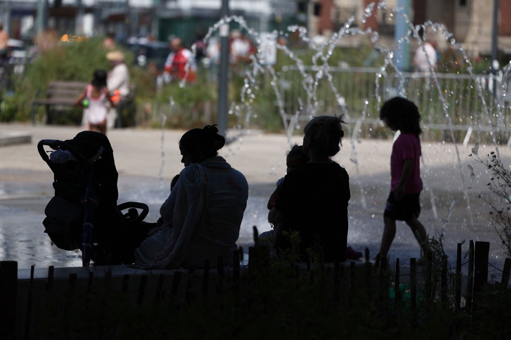 Des enfants et des passants se rafraîchissent près d'une fontaine pendant une canicule à Bobigny