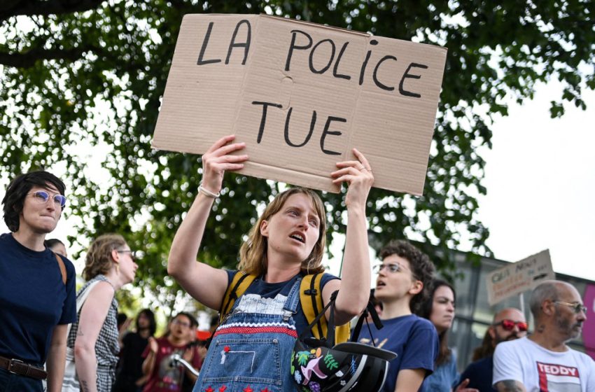 Un manifestant tient une pancarte « Police kills » lors d'un rassemblement contre les violences policières à Nantes en juin 2023.