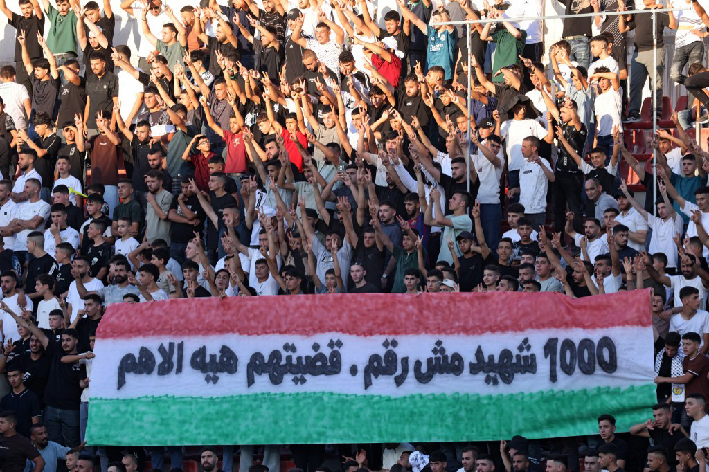 Supporters brandissant une banderole « 1 000 martyrs n’est pas un chiffre » lors d’un match à Al-Ram