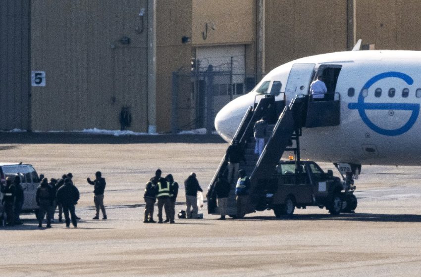 Des agents de l’ICE encadrent des personnes expulsées avant leur embarquement